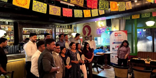 corporate employes are standing with award organized by travelites